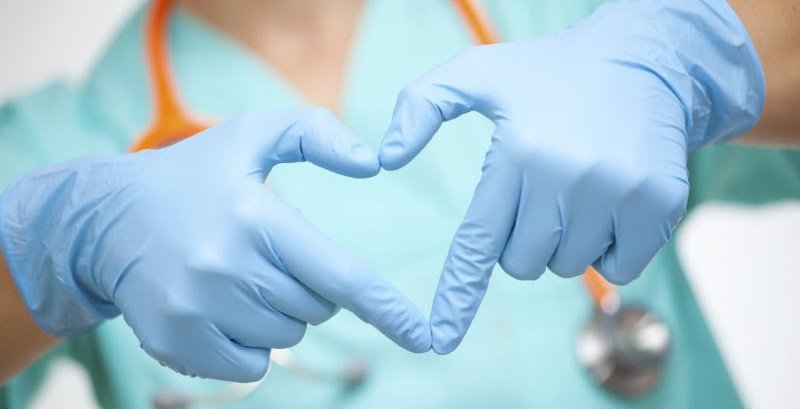 Two gloved hands forming a heart — nurse caring symbol